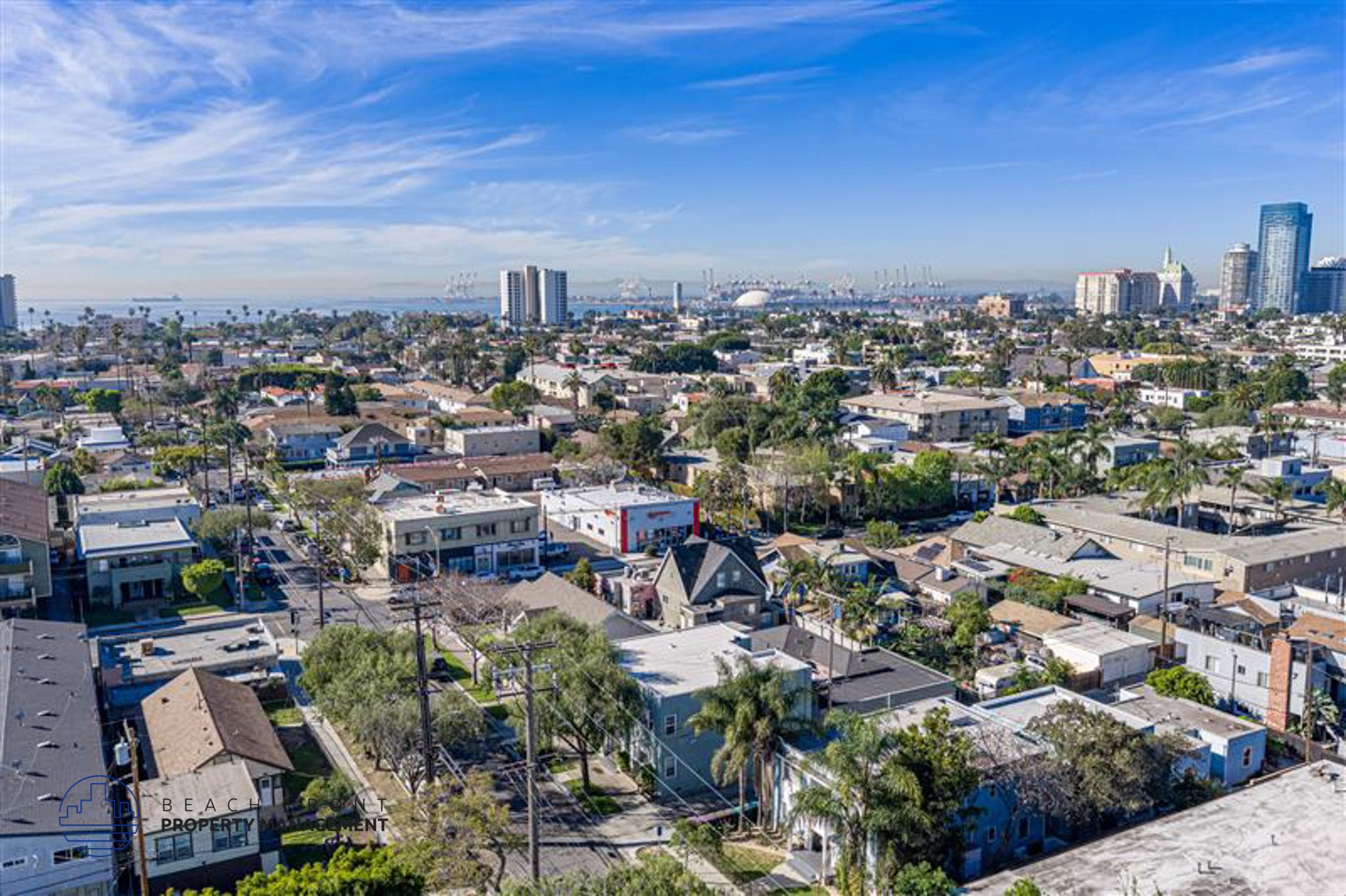 A cityscape with a mix of residential and commercial buildings under a clear sky.