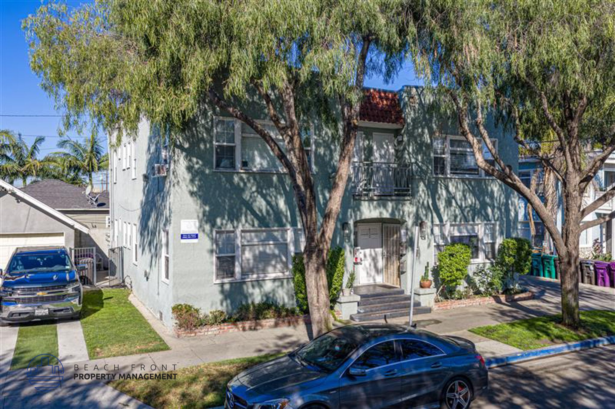 A blue car is parked in front of a house.