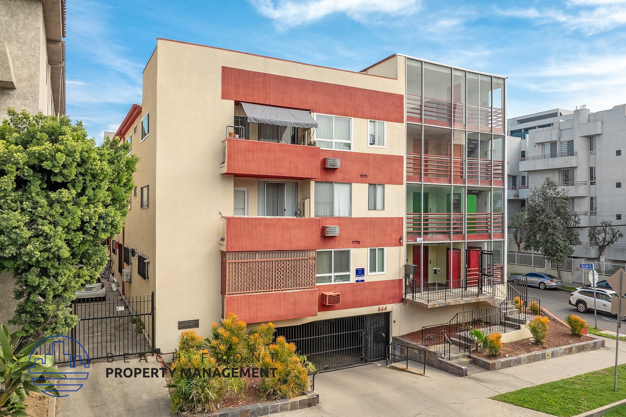 A modern apartment building with a red and beige facade.