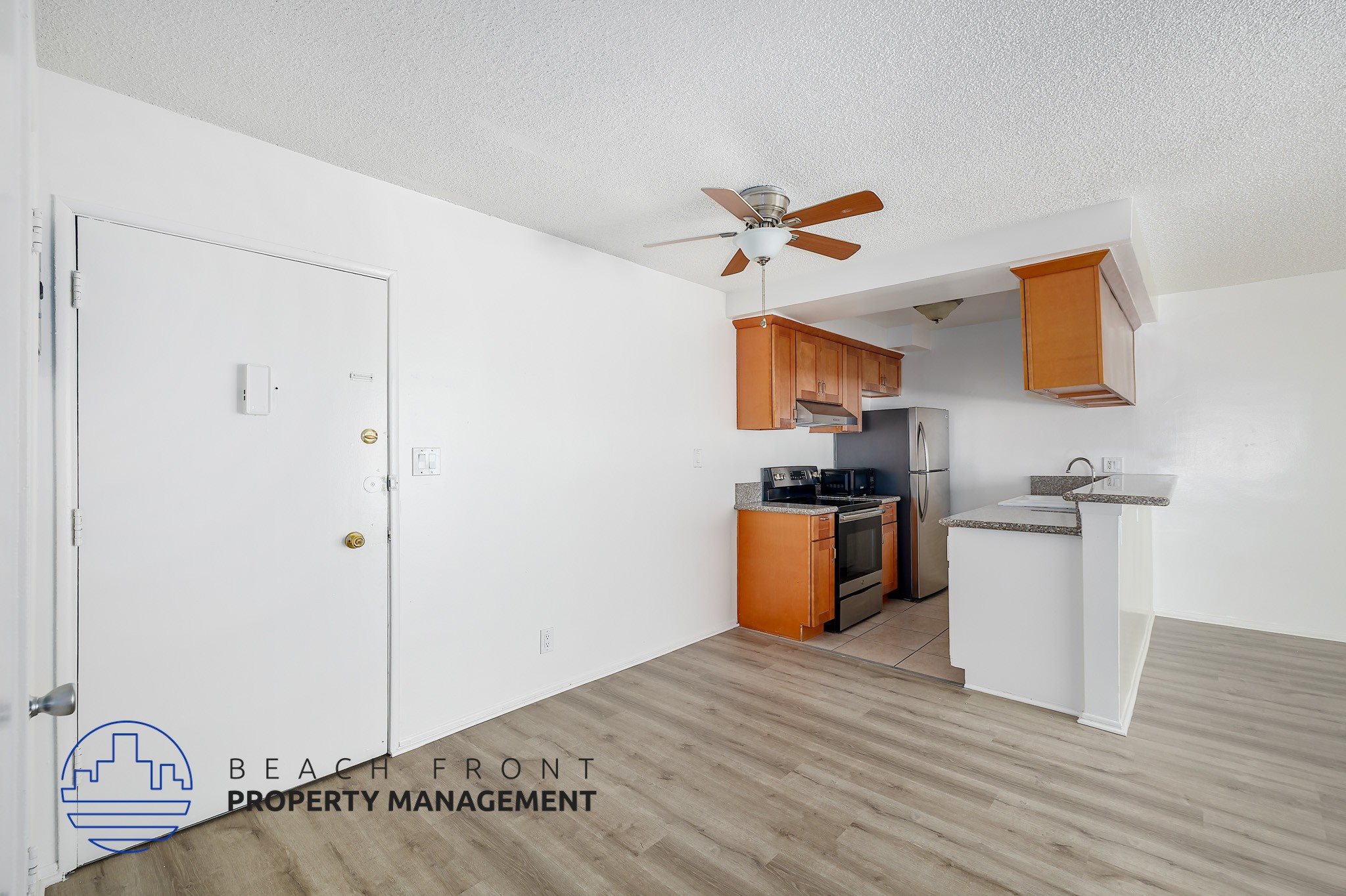 A kitchen area with a refrigerator, microwave, and sink.