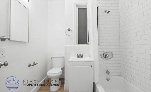 A white bathroom with a toilet, sink, and bathtub.