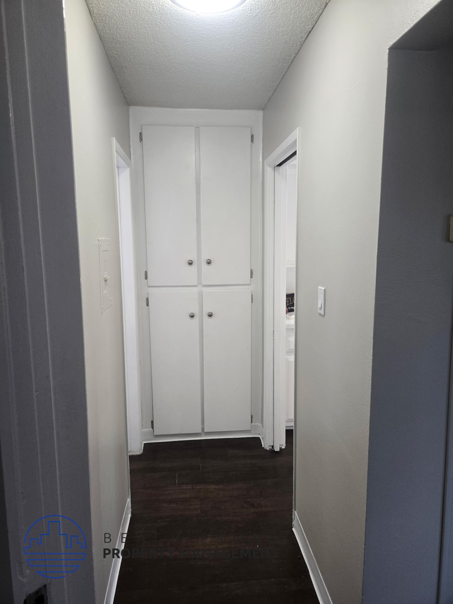 A hallway with a white door and a white cabinet.