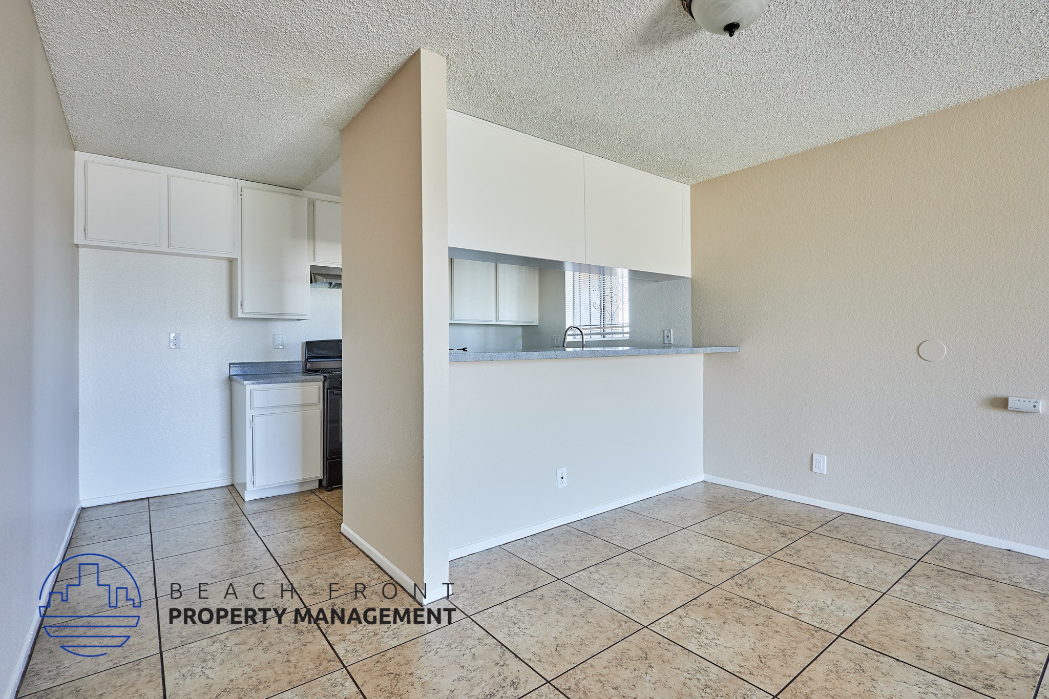 A kitchen area with a countertop and cabinets is visible from the living room.