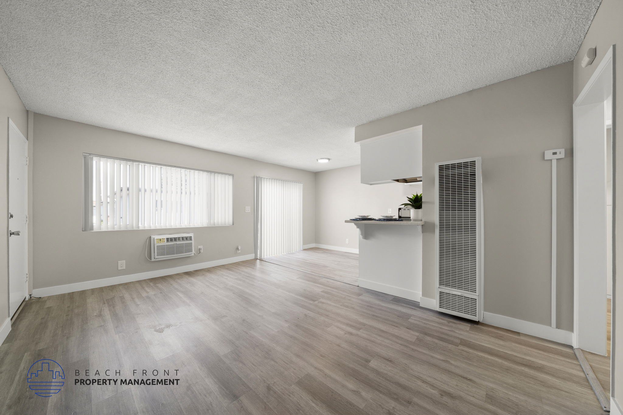 A spacious room with wooden flooring and a white ceiling.