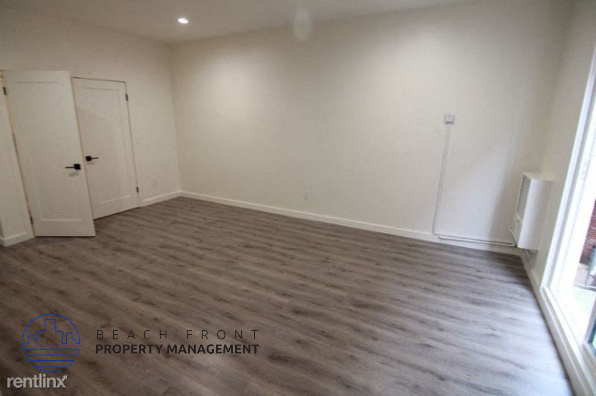 a empty room with white walls and a wooden floor