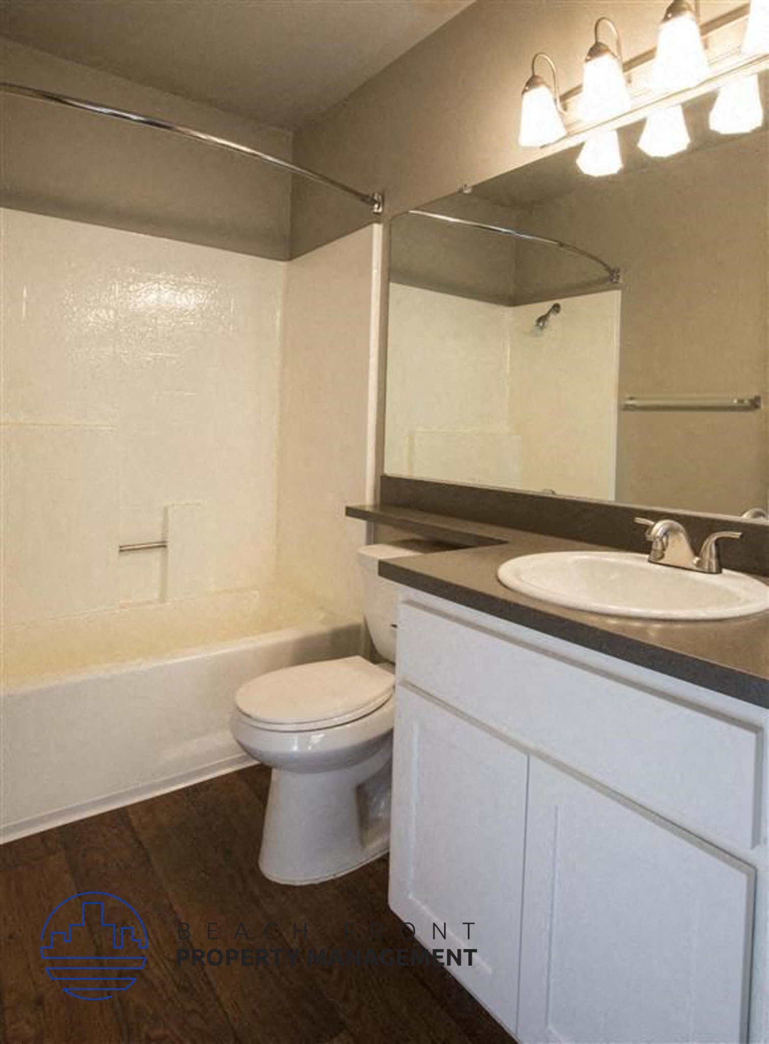 A white toilet in a bathroom with a sink and mirror.