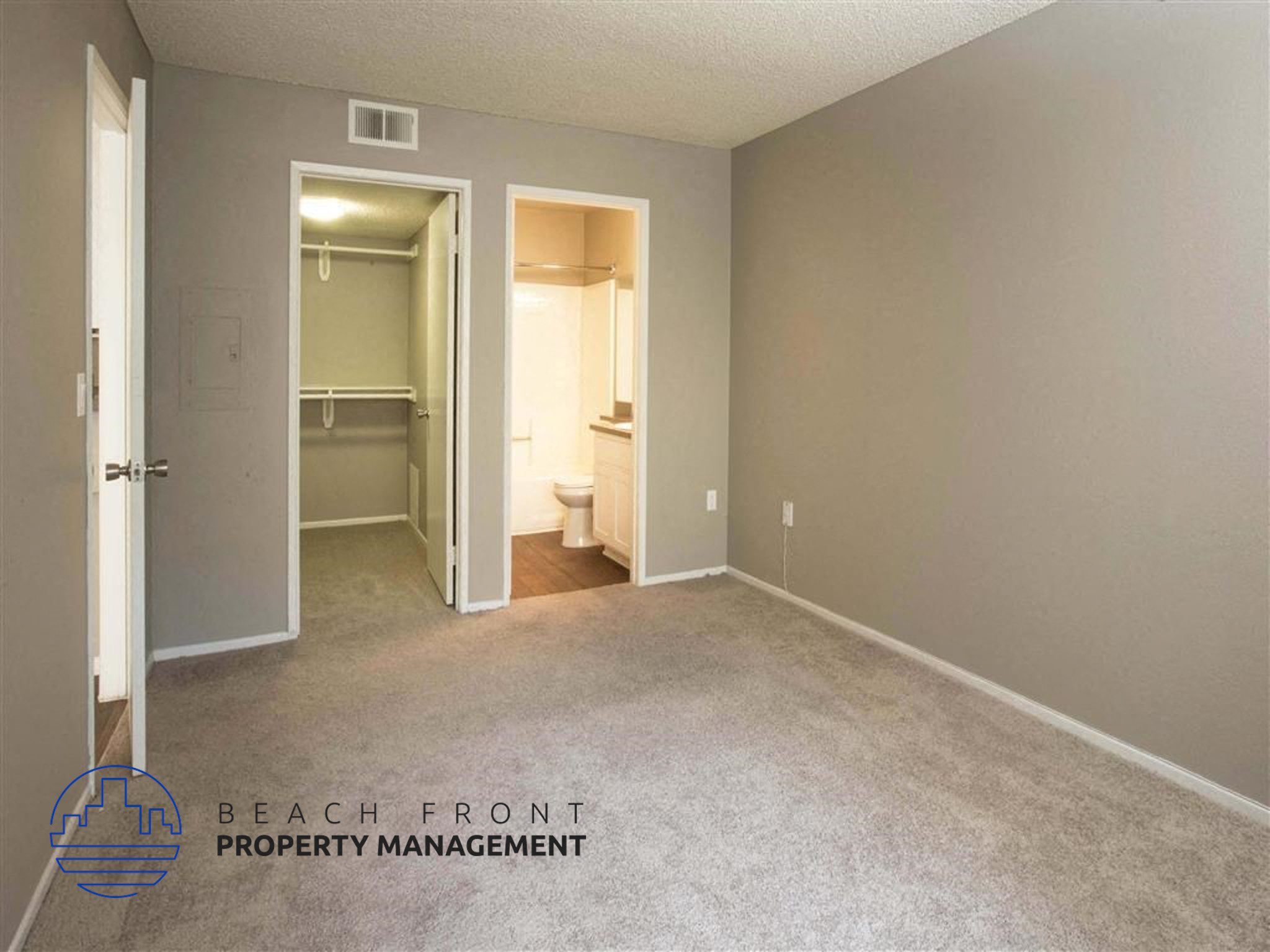 a bedroom with a carpeted floor and a door to a bathroom