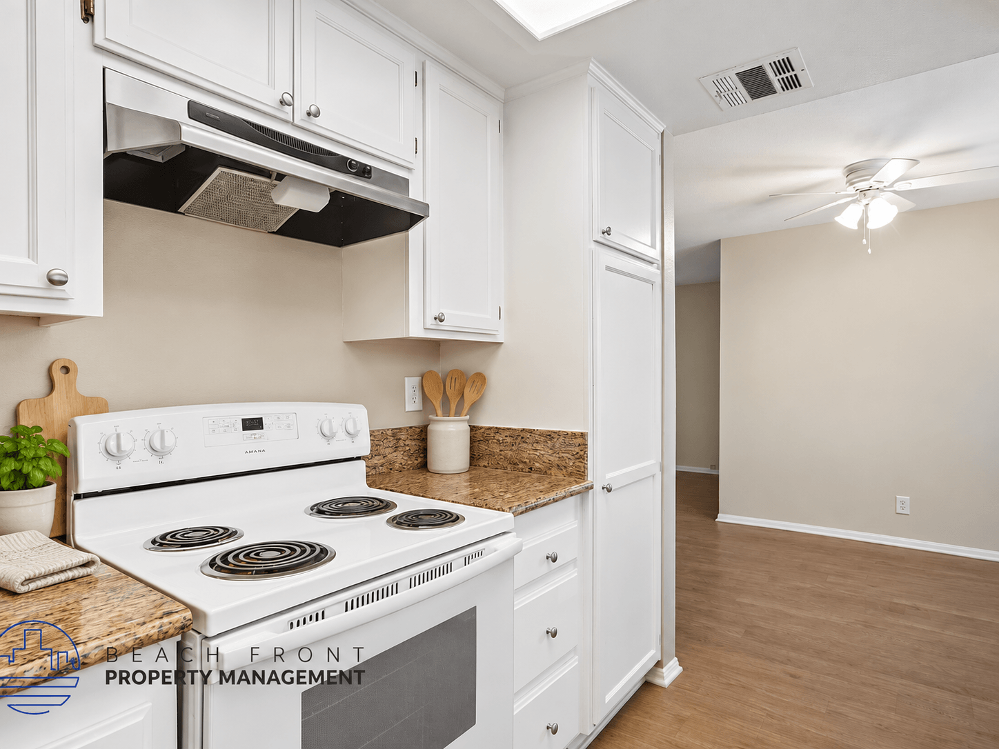 A kitchen with a stove top oven and white cabinets.