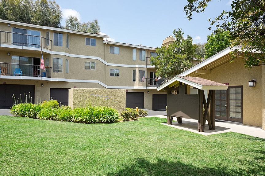 an apartment building with a yard and a picnic table