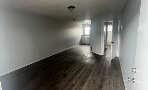 A long hallway with wooden floors and white walls.