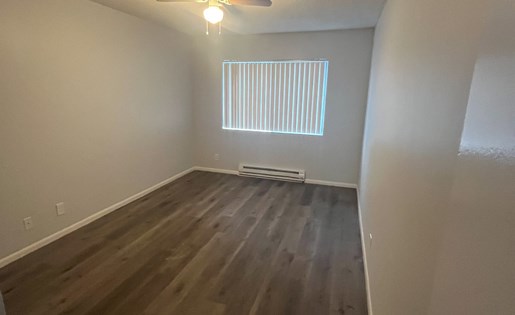 A room with wooden floors and a ceiling fan.