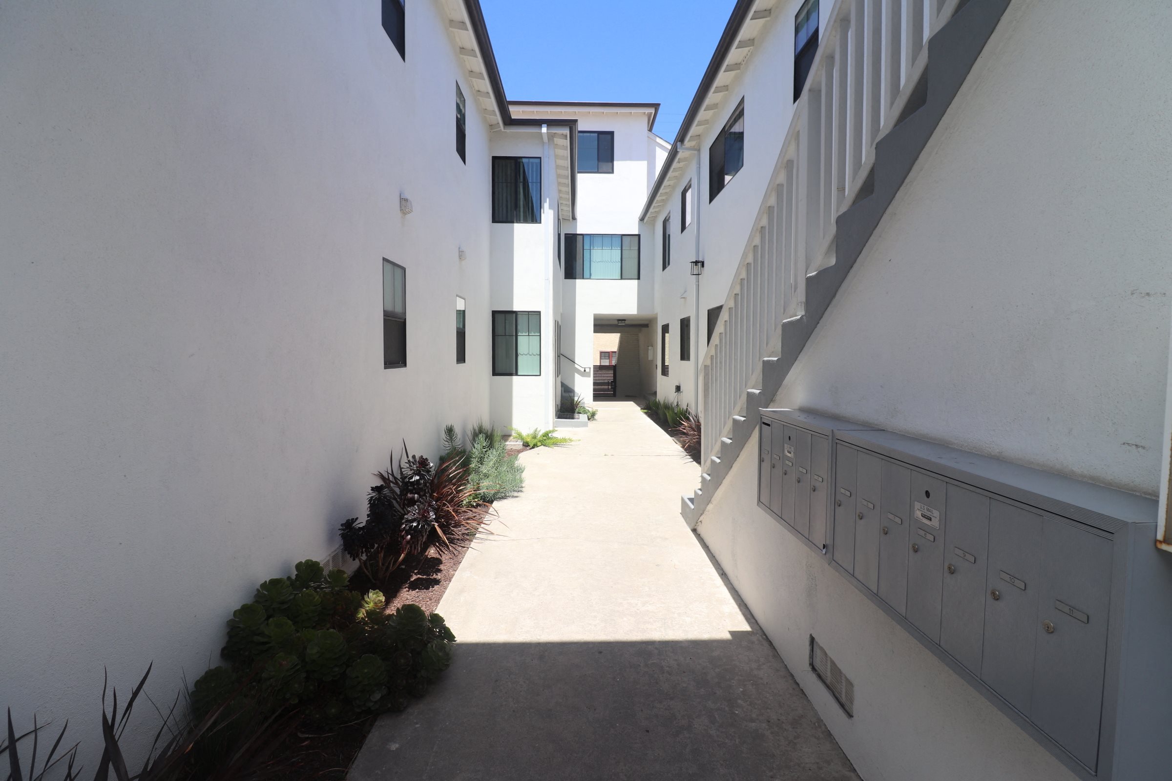 A long, narrow walkway between two white buildings.