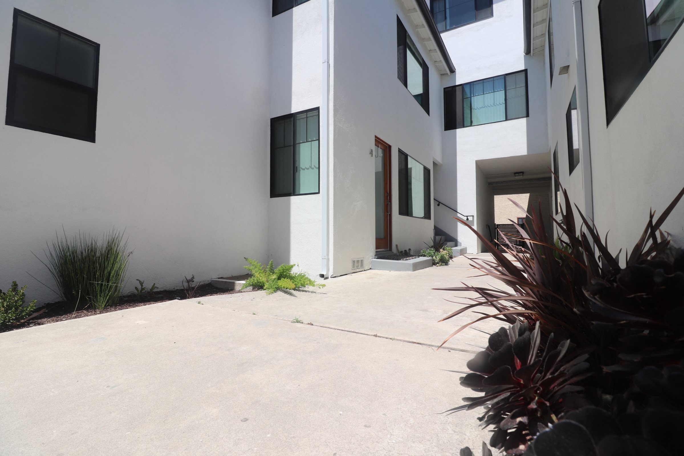 A white building with a black window and a door.