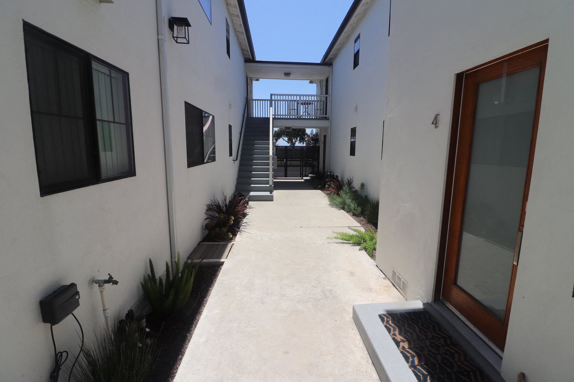 A small patio with a staircase leading to a balcony.