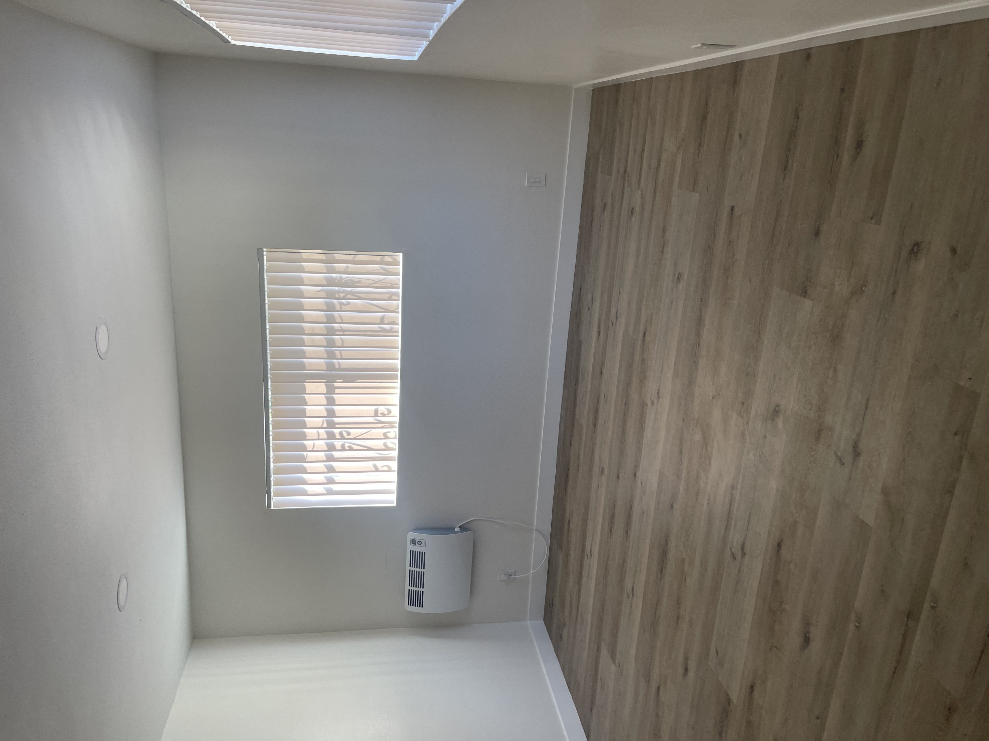 living room with a window and a wooden wall