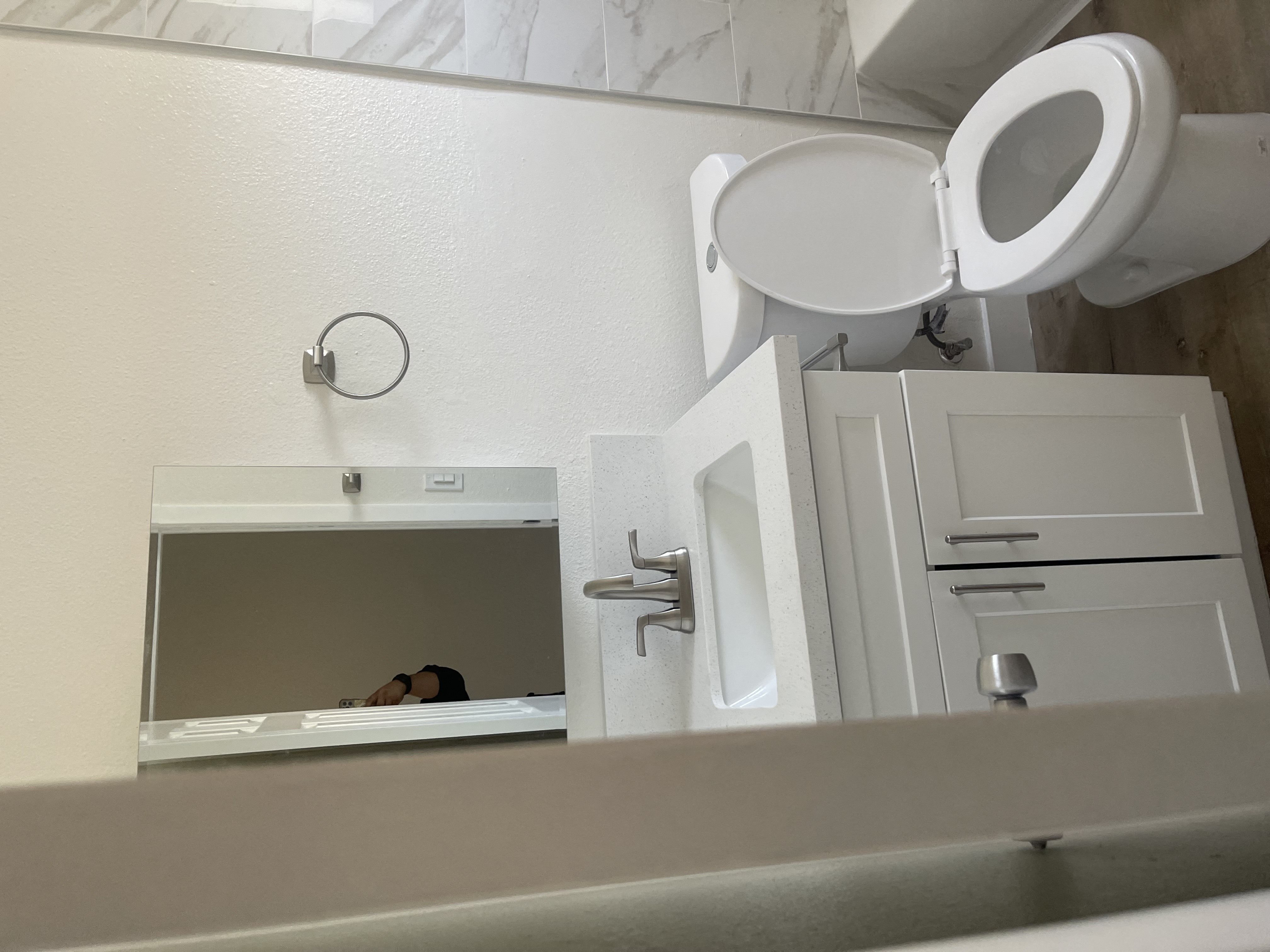 a bathroom with a mirror and a toilet and a sink