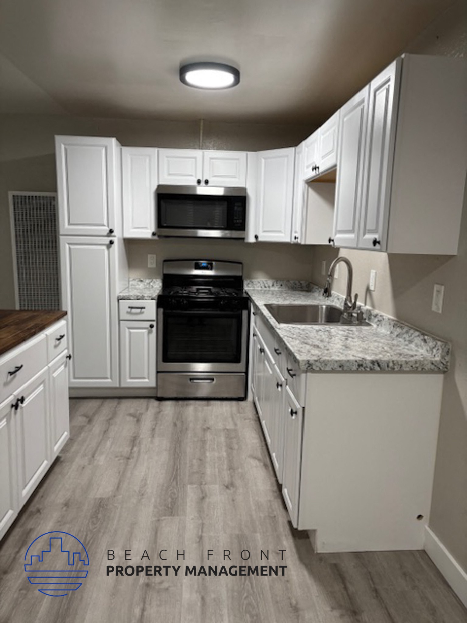 A kitchen with white cabinets and a granite countertop.