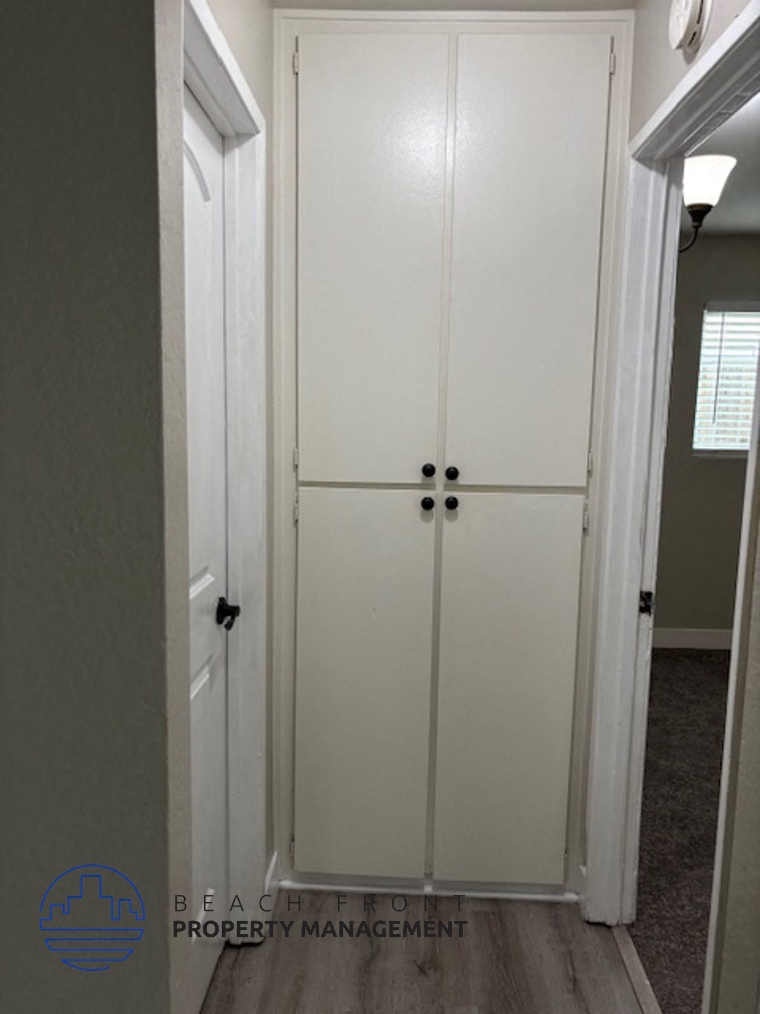 A white double door is closed and has a handle on each side.