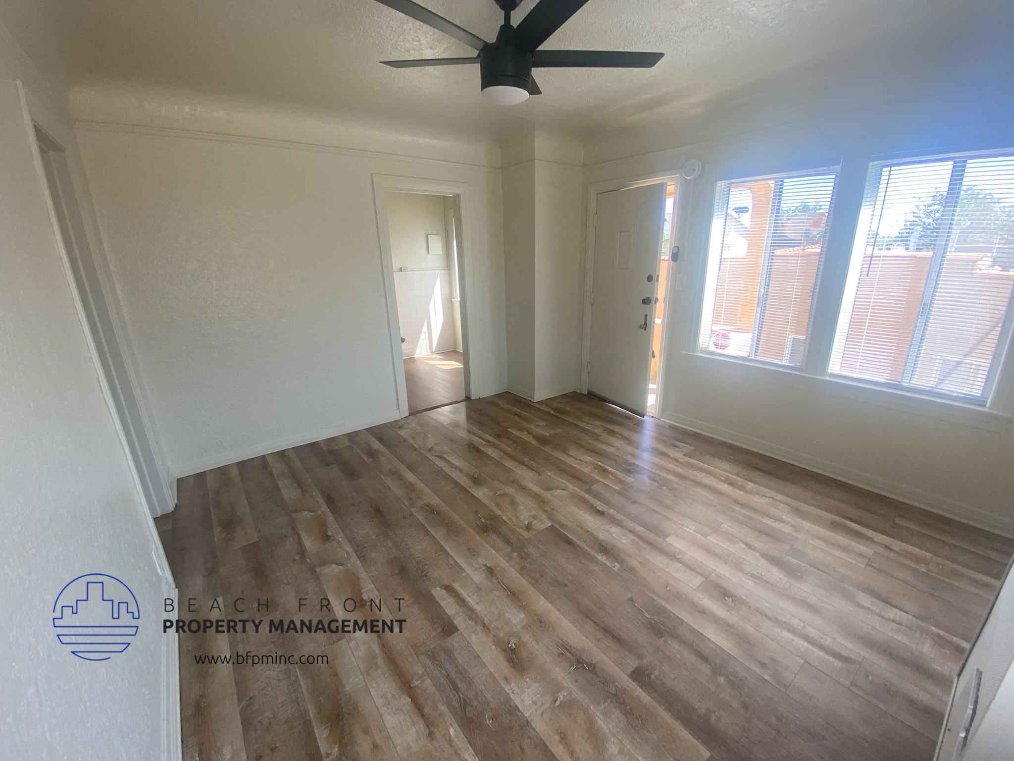 A room with wooden flooring and a ceiling fan.