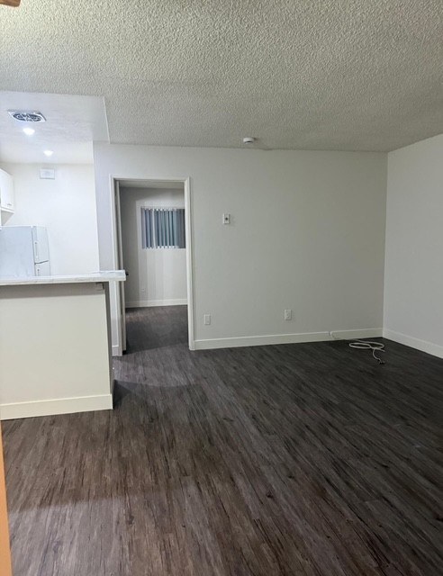 A room with a white wall and a wooden floor.
