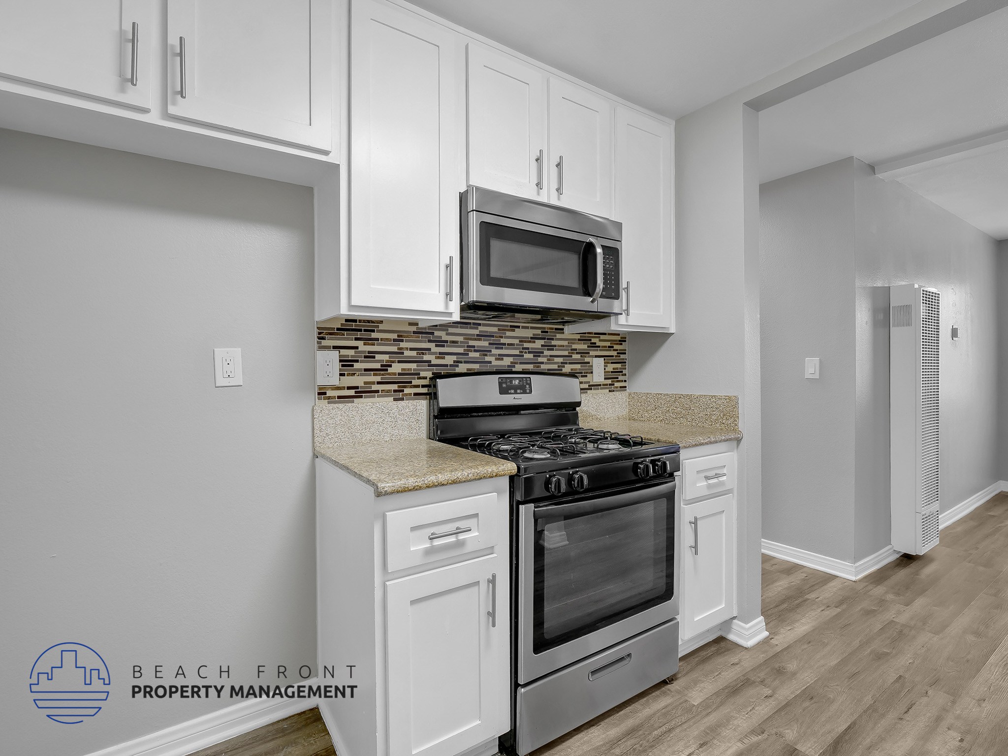 A kitchen with a stove, microwave, and cabinets.