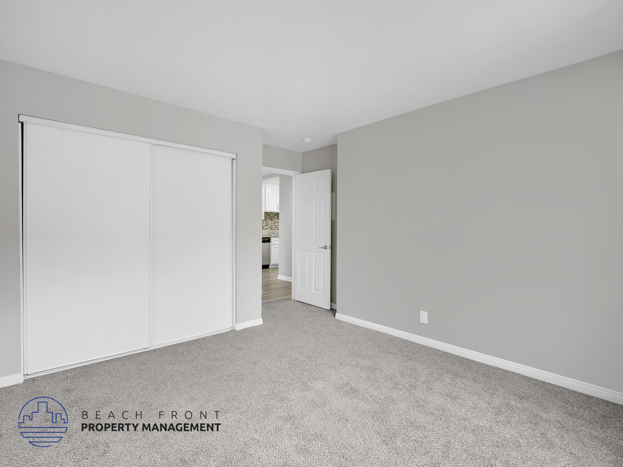 A room with a carpeted floor and a sliding door.