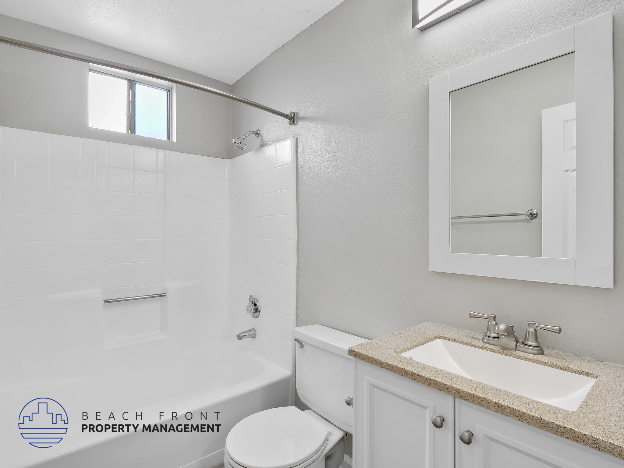 A white bathroom with a toilet, sink, and shower.