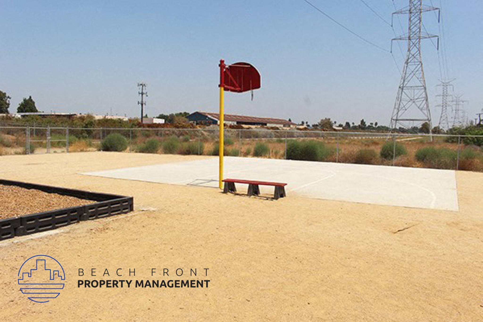 a basketball court with a bench and a flag in the dirt,a basketball court with a bench and a flag in the dirt