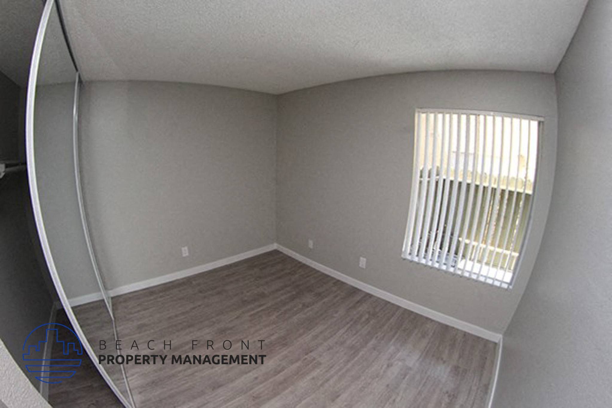 the interior of an empty room with wood flooring and a window,the interior of an empty room with wood flooring and a window