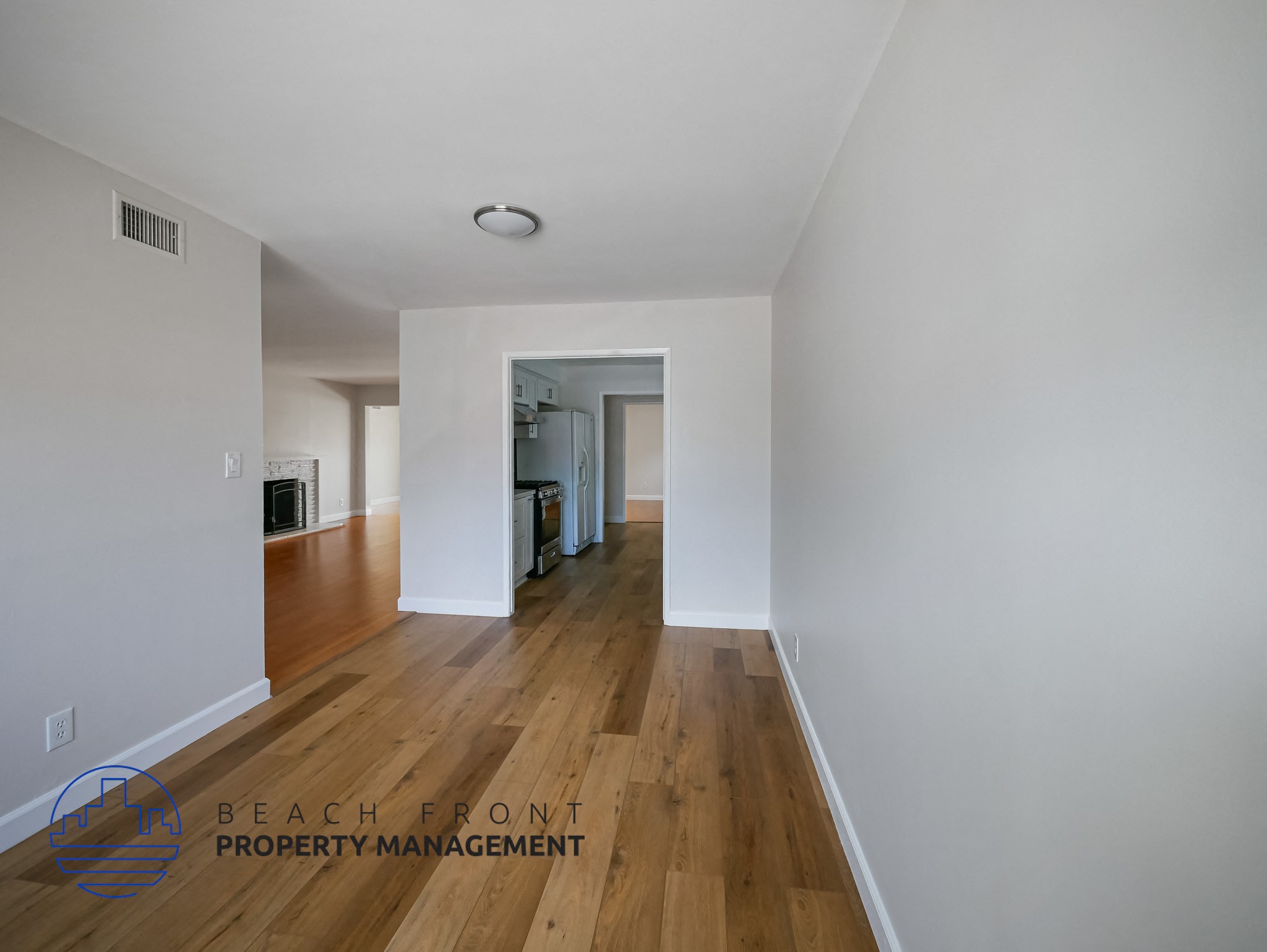 A long hallway with wooden floors and white walls.