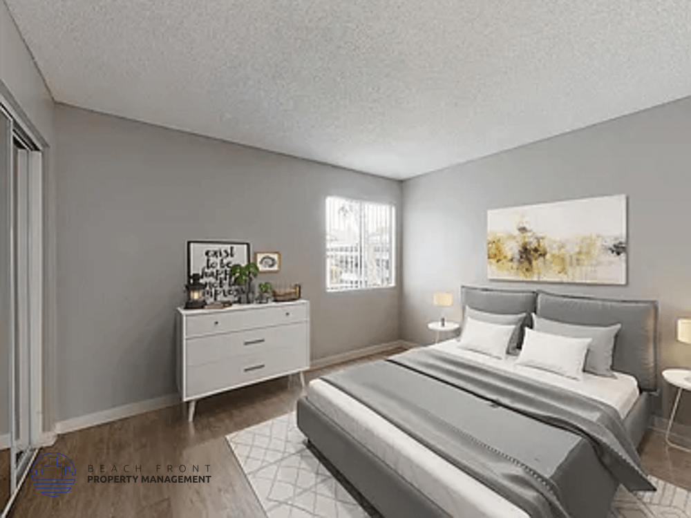 A well-lit bedroom with a large bed and a nightstand with a lamp.