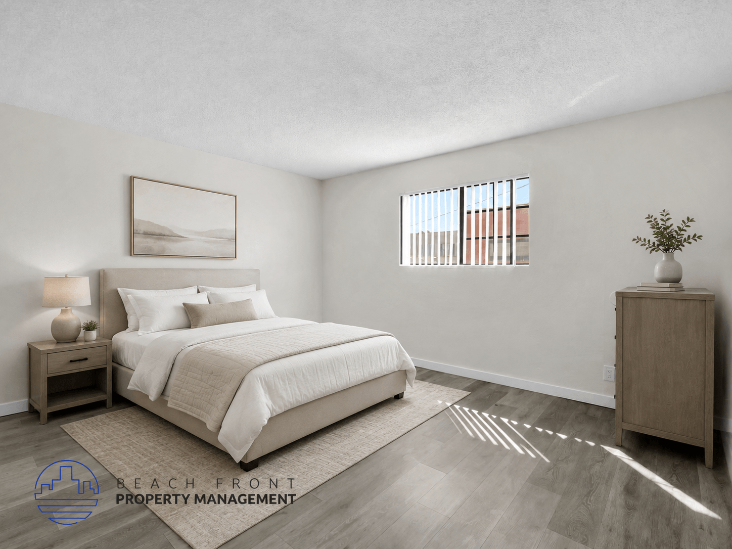 A well-lit bedroom with a large bed and a wooden nightstand.