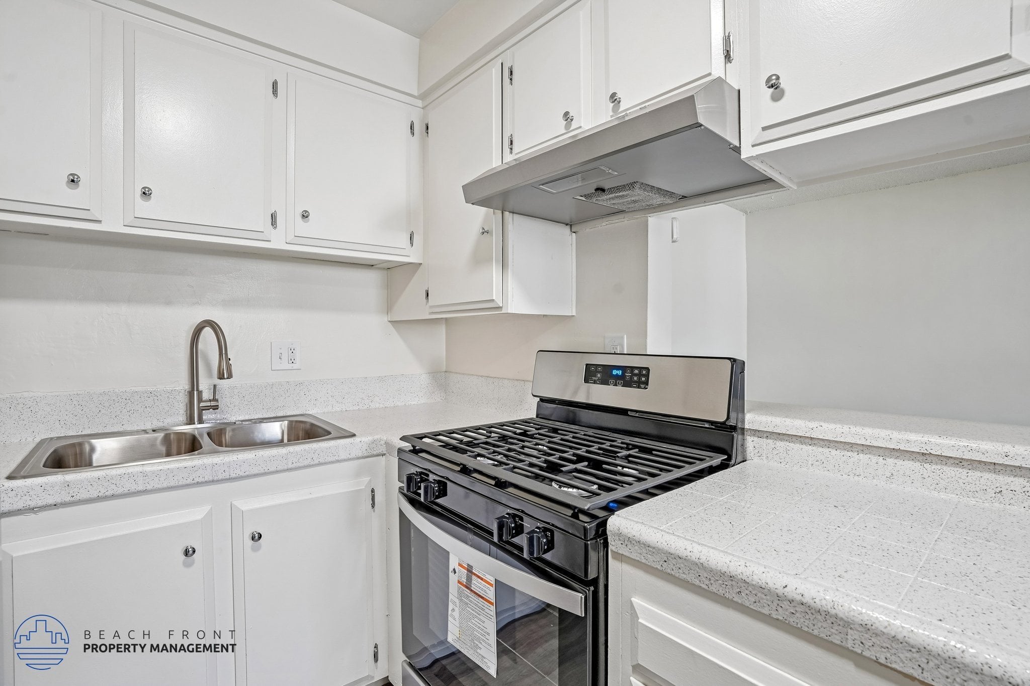 A modern kitchen with a stove top oven and a sink.