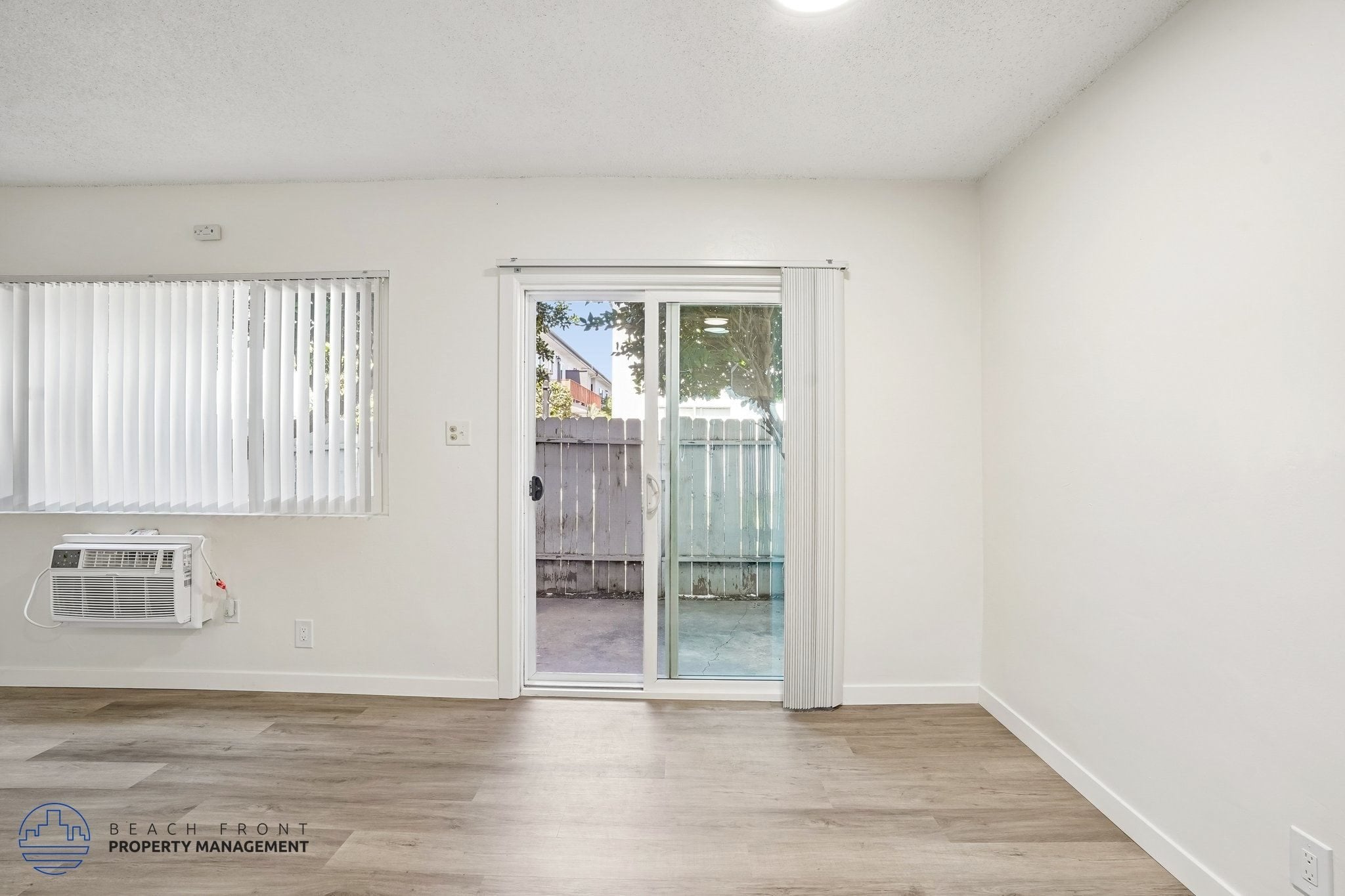 A room with a sliding glass door leading to a balcony.