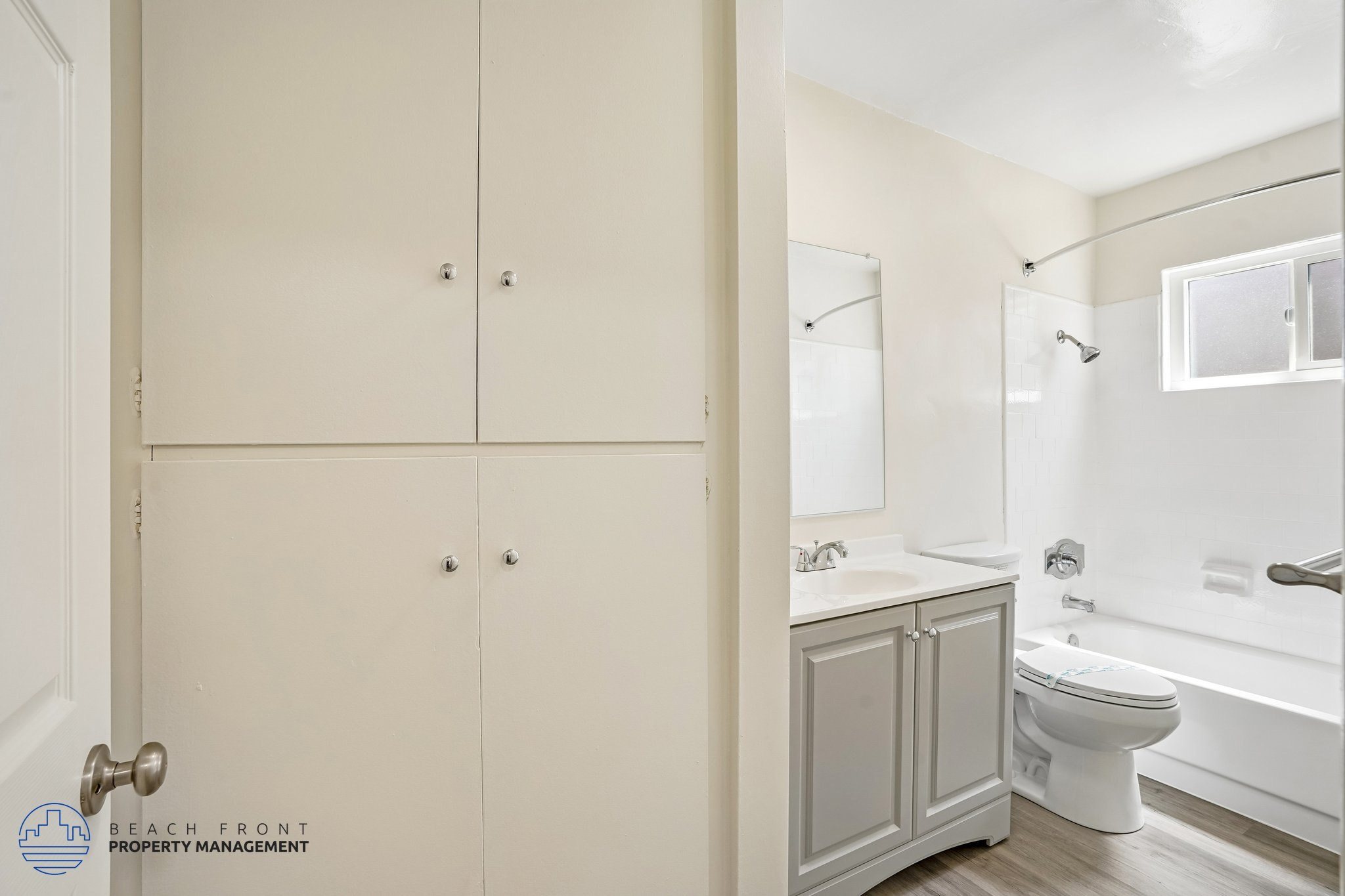 A white bathroom with a toilet, sink, and bathtub.