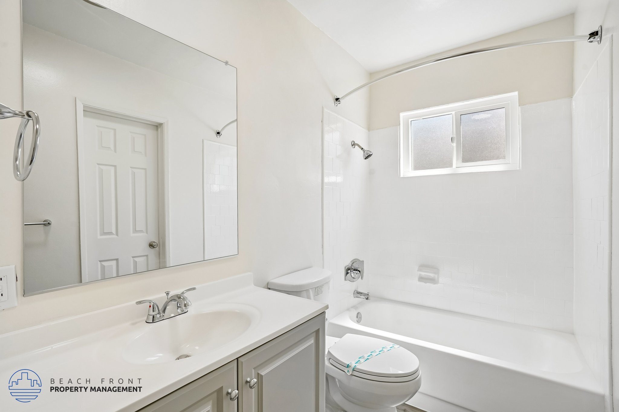A white bathroom with a sink, toilet, and bathtub.