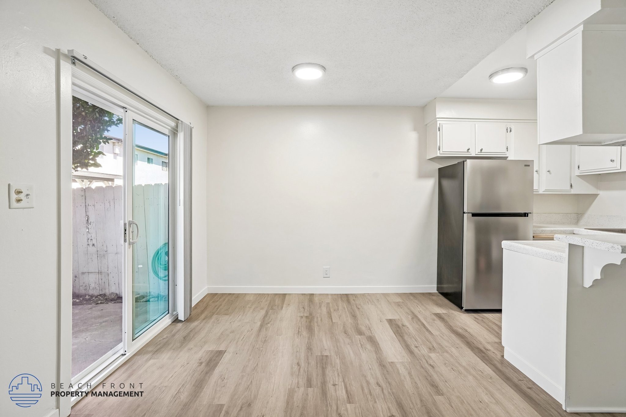 A kitchen with a refrigerator, dishwasher, and cabinets.