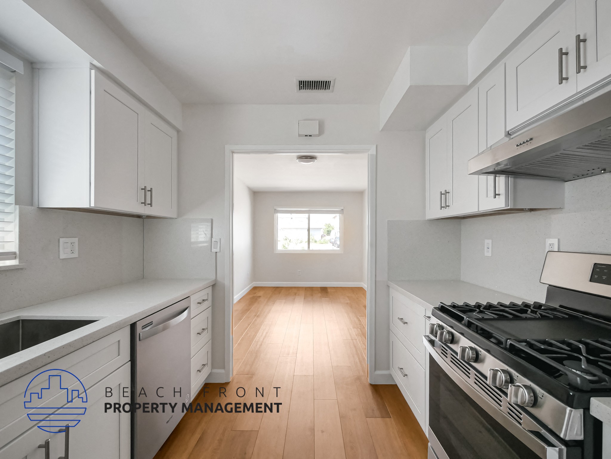 A kitchen with white cabinets and a stove top oven.