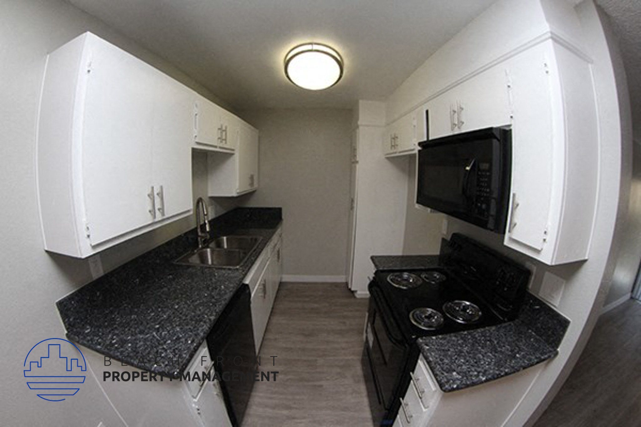 a small kitchen with white cabinets and black counter tops,a small kitchen with white cabinets and black counter tops