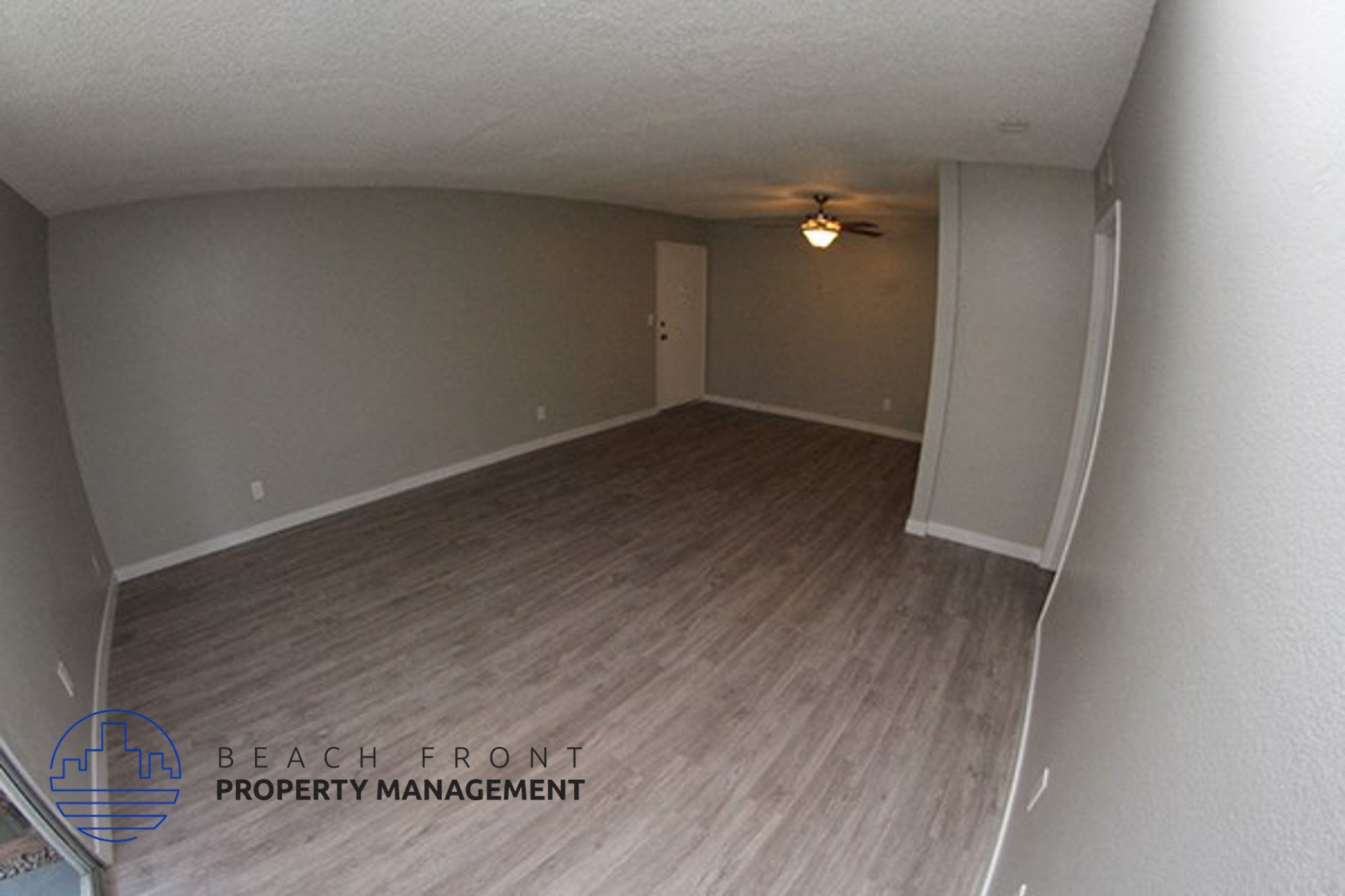 an empty living room with wood flooring and a ceiling fan,an empty living room with wood flooring and a ceiling fan