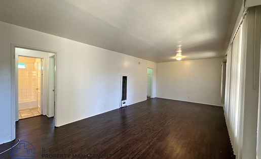A room with wooden floors and white walls.