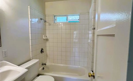 A bathroom with a toilet, sink, and bathtub.