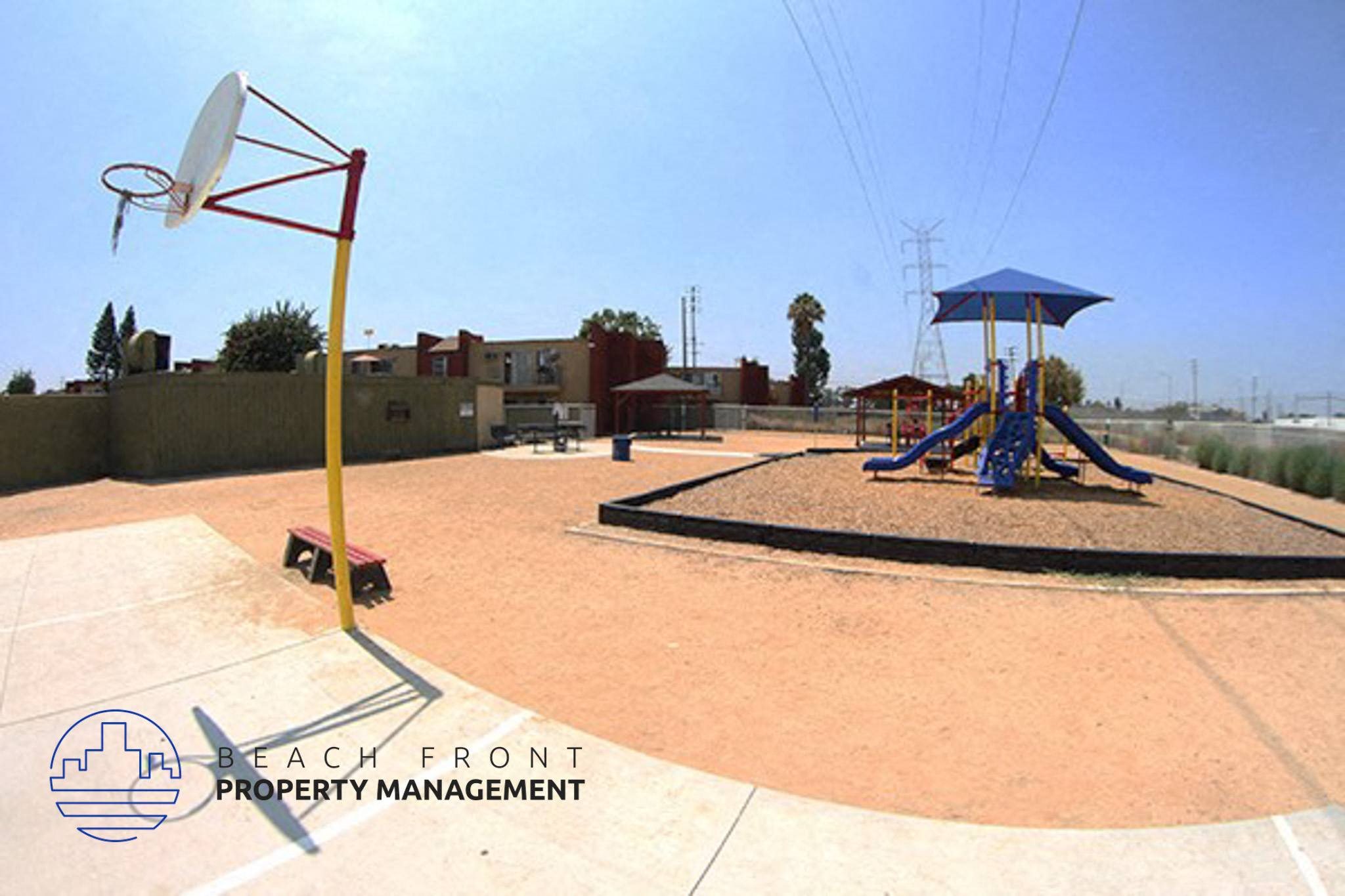 a playground with a swing set and a basketball court,a playground with a swing set and a basketball court