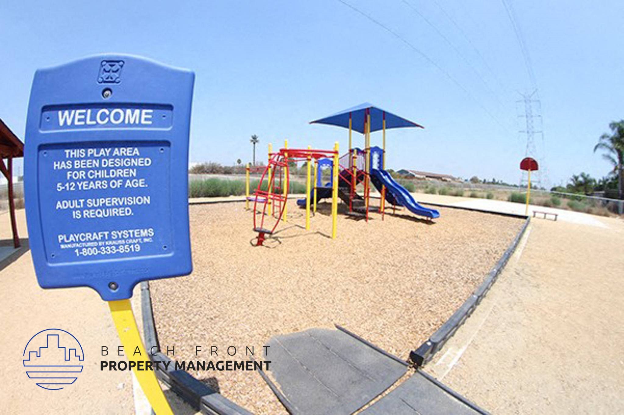 a playground with a blue sign in front of it,a playground with a blue sign in front of it