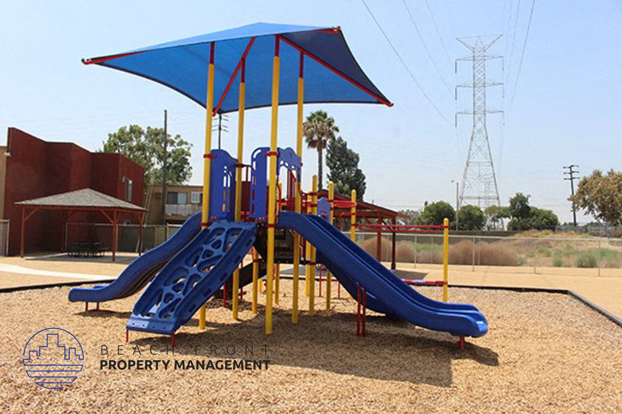 a playground with two slides and a umbrella,a playground with two slides and a umbrella