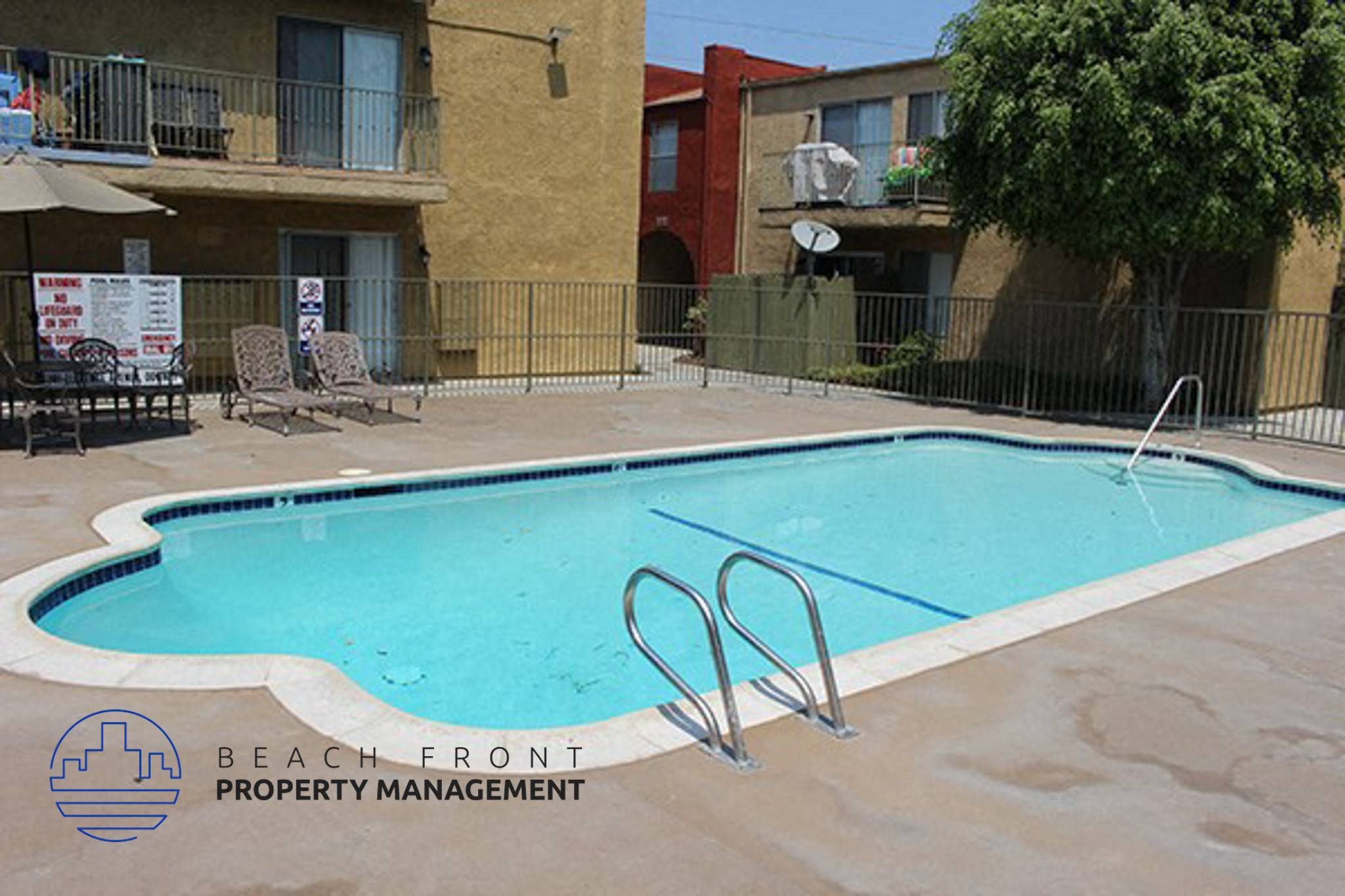 an empty swimming pool in front of an apartment building,an empty swimming pool in front of an apartment building