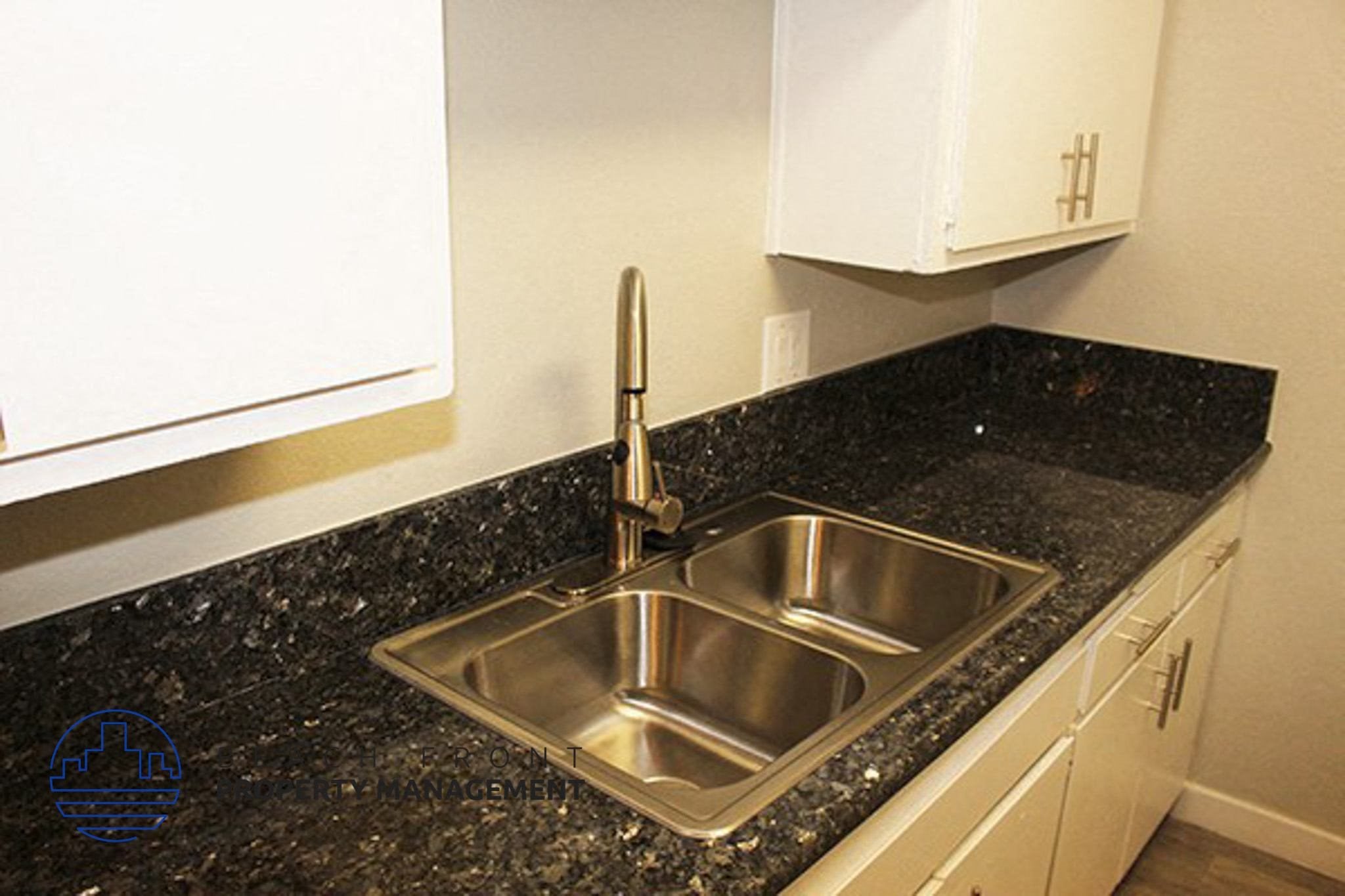 a kitchen with a sink and a granite counter top,a kitchen with a sink and a granite counter top