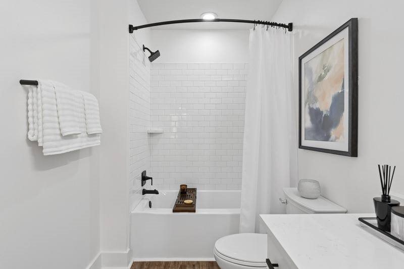 A white bathroom with a toilet, sink, and bathtub.