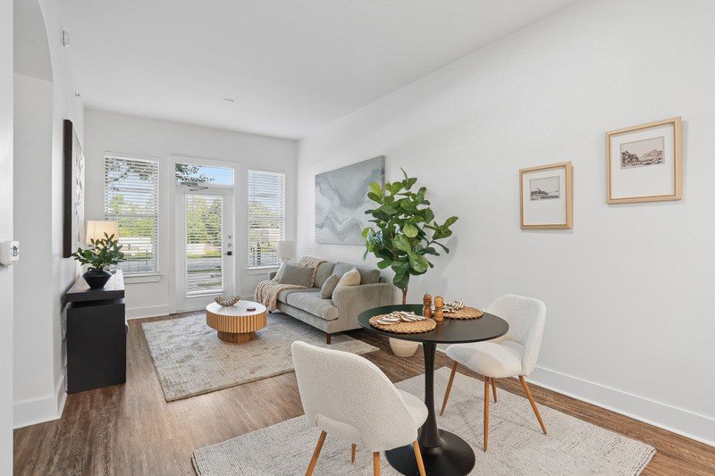 A modern living room with a dining table set for two.