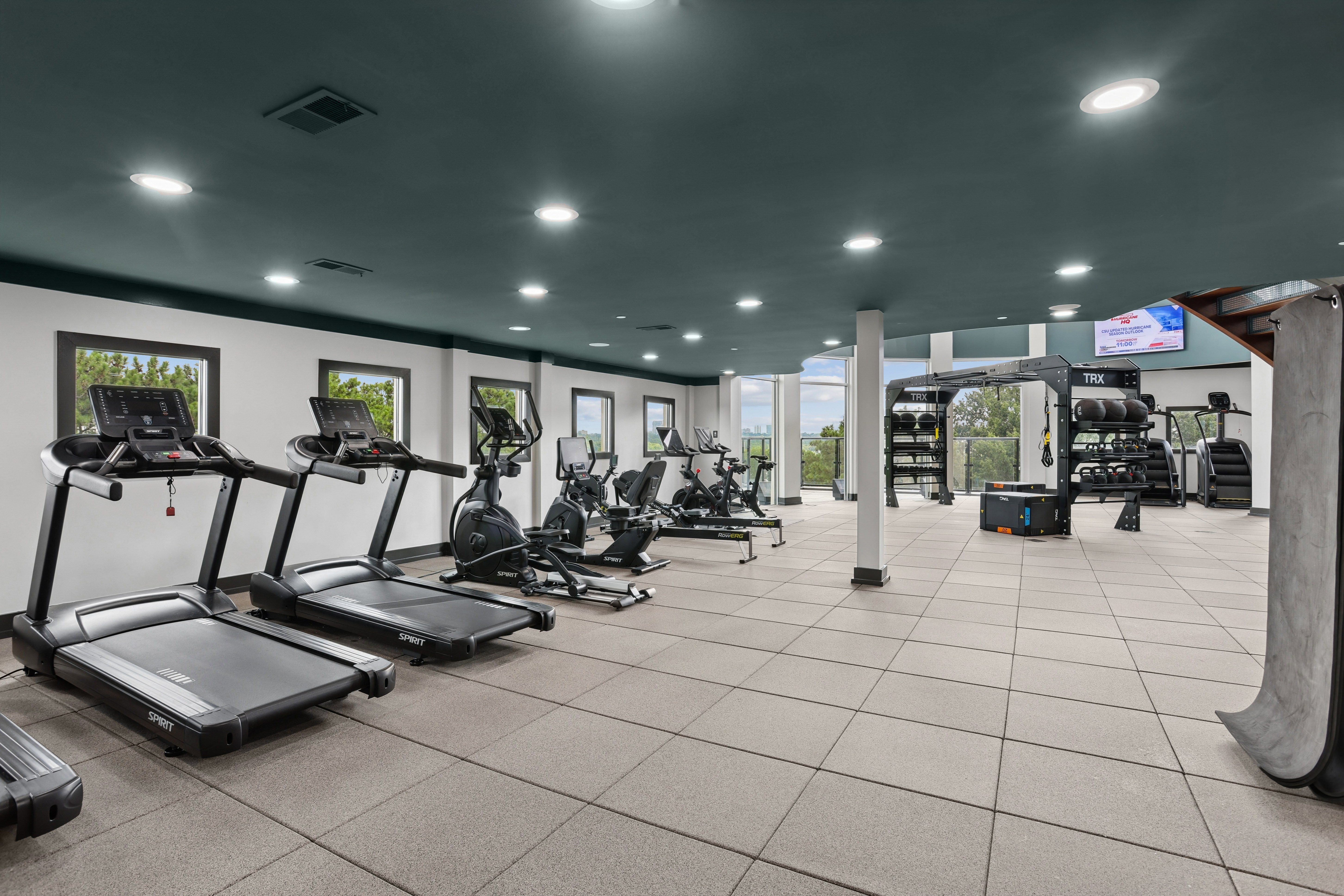 A gym with treadmills, exercise bikes, and other equipment.